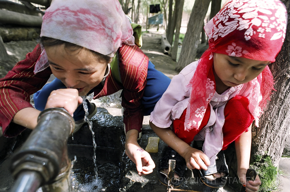 Uighur girls play near a local water source in Kashgar’s Old Town after school. Many of the homes in the Old Town lack adequate plumbing.  Residents come to this communal area to fetch water and do laundry.