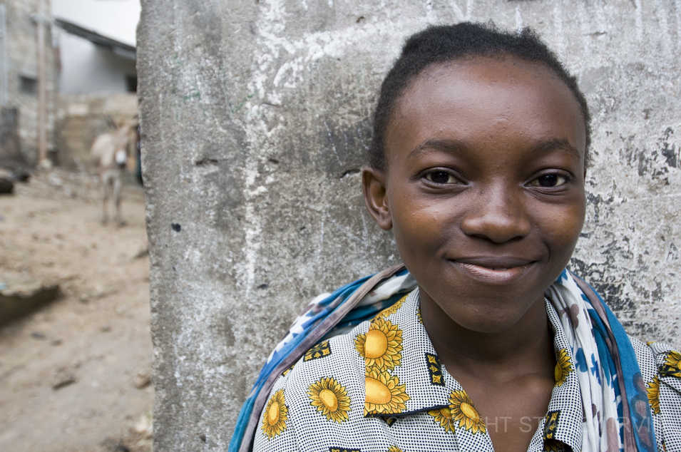 This young woman sits at her small fruit and vegetable stand on a corner deep in the residential area of Lamu.