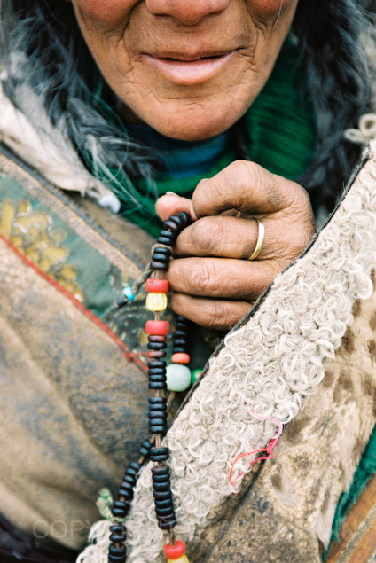 A Tibetan woman holds prayer beads in a town near Xiahe in Qinghai Province, China.