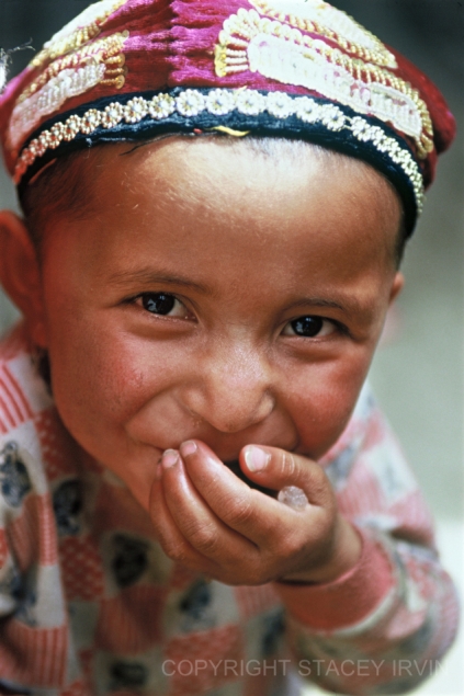 A Uighur boy pauses while eating some rock sugar on a little lane in Kashgar's Old Town.

Many of the children I have met in Kashgar love to practice English phrases.  This little boy asked me in English, "What time is it?"  To which I replied, "Beijing time or Xinjiang time?", though I knew I'd be asked for both.

All of China is officially on "Beijing time". However, in Kashgar the sun rises a full two hours after it does in Beijing. Most Uighurs choose to schedule their day according to the unofficial "Xinjiang time".